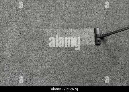 Vacuuming grey carpet. Clean area after using device, top view. Space for text Stock Photo