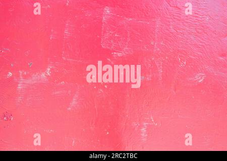 Red texture of a plastered old abandoned wall with a shadow from the sunlight Stock Photo