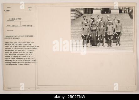 'Presentation of Distinguished Service medals to officers and Miss Hannah J. Patterson, including Secretary of War Newton Baker. Front row, left to right: Maj. Gen. Geo. Burr, Miss Hannah J. Patterson, Newton D. Baker, Gen. T.H. Barry. Other recipients include Col. William Spruance Jr., Col. James P. Kerr, Col. John S. Pair, Col. A. Owen Seaman, Col. Charles T. Harris, Col. W.D. Scott, Mr. Frank Scott, Lieut. Col. K.B. Harmon, and Lieut. Col. Augustus Trowbridge. Photograph taken on June 16, 1919, by a photographer from the Signal Corps. Image number 53999, and it's description mentions a symb Stock Photo