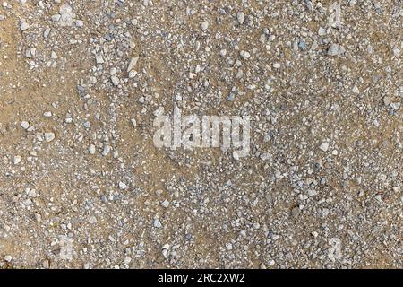 Detail of surface texture with small pebble rock on dirty ground. Stock Photo