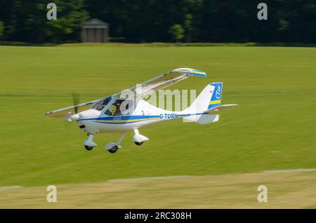 Flight Design CT-SW plane G-TORN taking off at Heveningham countryside grass airstrip in Suffolk, UK. Tree lined grass runway. German ultralight Stock Photo