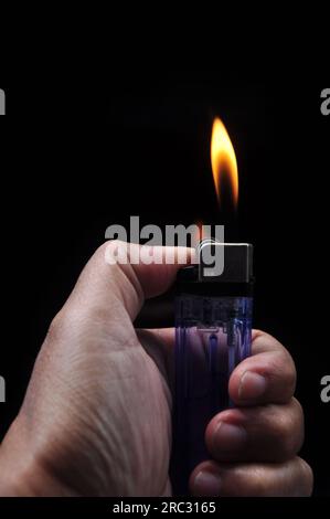 Turn on a gasoline lighter on a black background Stock Photo