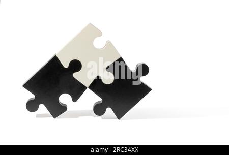 Black and white puzzle pieces with different shapes isolated on simple light background Stock Photo
