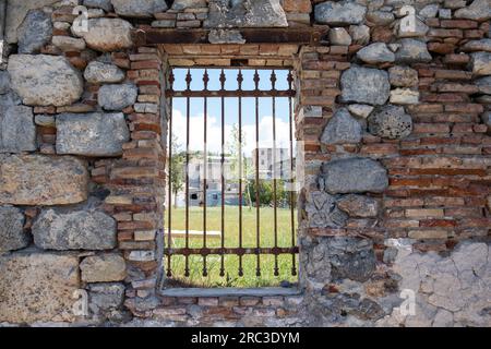 Elefsina, Attica Greece. 2023 European Capital of Culture. View through rusty window grid of old Olive Mill Factory and Open Air Theater. Stock Photo