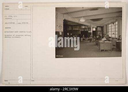 Interior of executive office at Operations Base Section Plant in New York. The photograph shows personnel working in the office. The image was taken by Lt. Lyon on April 14, 1919, and is numbered as subject 47198. Includes Bud H's notes. Stock Photo