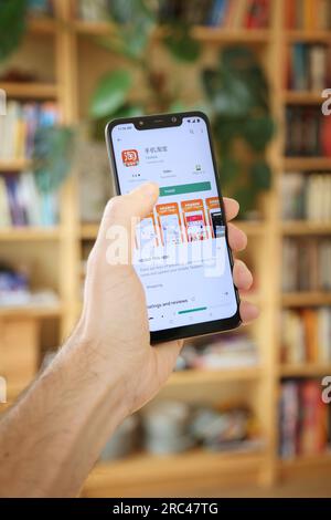 WARSAW, POLAND - JANUARY 29, 2021: User installing Taobao online shopping mobile app on an Android OS, Xiaomi smart phone. Stock Photo