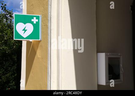Public automated external defibrillator (AED) portable medical device in Austria. The words on the box: Alarmgesichert means alarm protected. Stock Photo