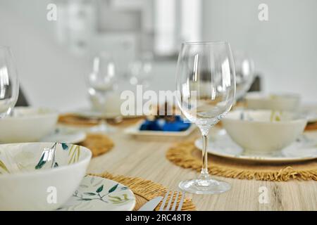 Close up of empty wine glasses and dinnerware is ready for lunch served on dining table, no people. Life event celebration, dinning at home Stock Photo