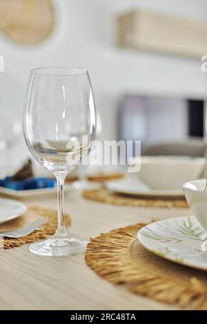 Vertical shot of empty wine glasses and dinnerware is ready for lunch served on dining table, no people Stock Photo
