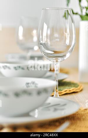 Vertical shot of empty wine glasses and dinnerware is ready for lunch served on dining table, no people Stock Photo