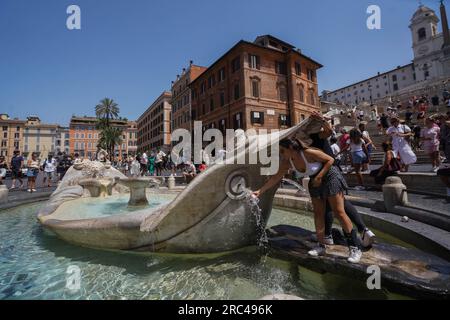 Rome, Italy. 12 July 2023 People cool off at Fontana della Barcaccia, as Rome experiences high temperatures. The Italian health ministry has issued a red alert heatwave warning for eight major cities in Italy as temperatures are forecast to tip above 40°C/104F. Credit amer ghazzal/Alamy Live News Stock Photo