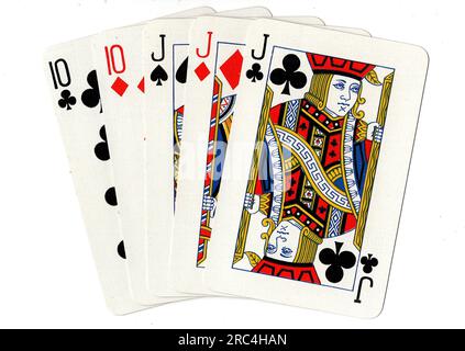 A poker hand of playing cards showing a full house of jacks and tens on a white background. Stock Photo