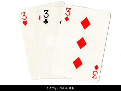 Vintage playing cards showing three threes on a white background. Stock Photo