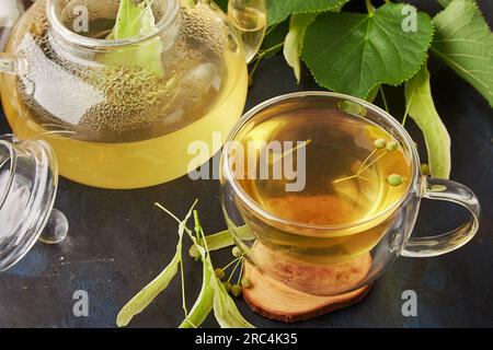 Cup of healthy natural linden, chamomile tea blossoms. Natural relaxing drink, benefits and properties concept. Stock Photo