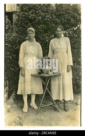 Original early 1920's era postcard of 2 pretty, serious looking teenage sisters of mixed aboriginal or Torres Strait Island descent called Lillie and Florrie wearing Western summer clothes, fostered into white families, removed from their family by 'removalists' who were mostly white male missionaries, patrol officers and police officers -  this scandal is known as the Stolen Generations or Stolen Children, Australia Stock Photo