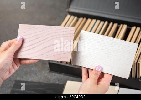 Choice of floor color from wood samples. A female designer chooses a floor color using samples of different shades. The concept of choosing a new Stock Photo