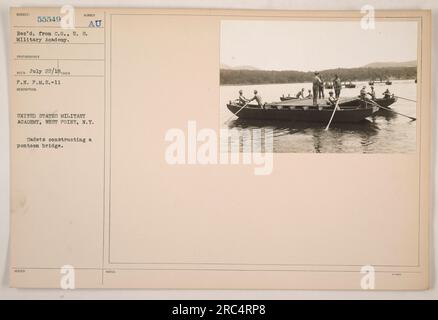 Cadets from the United States Military Academy in West Point, New York working together to construct a pontoon bridge. The photograph was taken on July 22, 1918, and the image is labeled as Subject 55549, received from the Commanding Officer of the U.S. Military Academy. Stock Photo