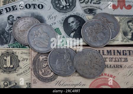 Old west US banknotes and silver certificates with silver dollar coins background Stock Photo