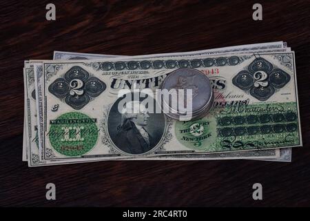 Old west US banknotes and silver certificates with silver dollar coins background Stock Photo