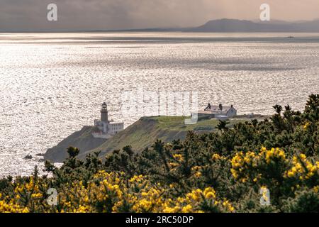 Howth, Ireland,  13th. March, 2023: Howth Lighthouse on the peninsular of Dublin Bay Silhouetted against the morning sun. Stock Photo