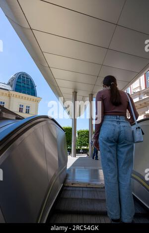 Vienna, Austria - June 13, 2023: The girl leaves the subway on the escalator Stock Photo