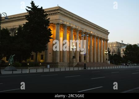 Baku, Azerbaijan - June 25, 2023: Evening shot of the Independence Museum on Neftchilar Boulevard, with lights glowing behind its columns Stock Photo