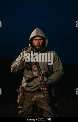 Portrait of an armed Ukrainian soldier wearing hoody  and looking in the camera Stock Photo