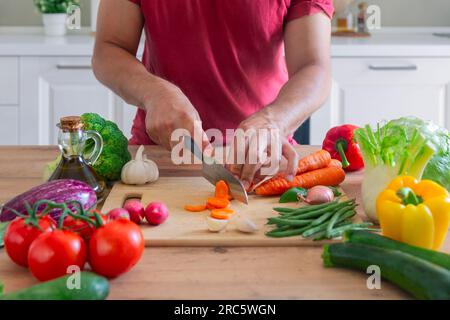 Man hands cutting vegetables in the kitchen Stock Photo