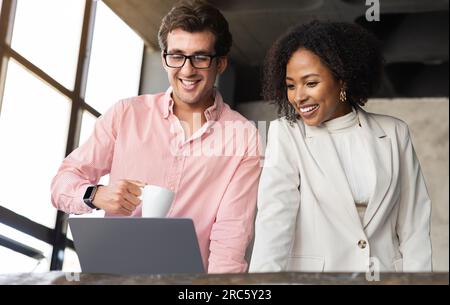 Happy multicultural managers discussing business project, smiling Stock Photo