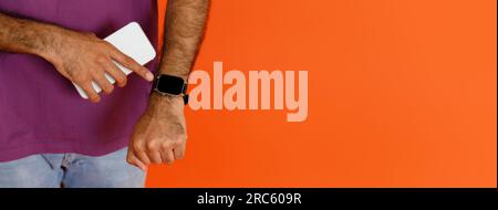 Unrecognizable dark-skinned man using application on smartphone and smart watch Stock Photo