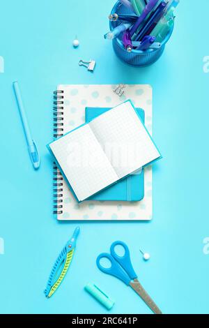 Composition with notebooks and different school stationery on blue background Stock Photo