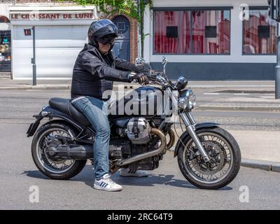 Motor cyclist on Moto Guzzi motorbike waiting at traffic lights city center - Tours, Indre-et-Loire (37), France. Stock Photo