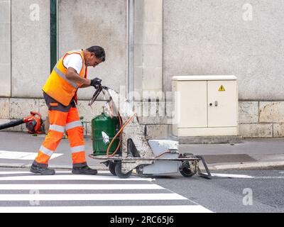 Council workmen painting pedestrian crossing markings in city center - Tours, Indre-et-Loire (37), France. Stock Photo