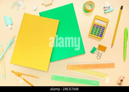 Notebooks with different stationery on pale yellow background Stock Photo
