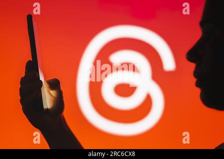 Brazil. 12th July, 2023. In this photo illustration, a person holds a smartphone with the Threads logo in the background. (Credit Image: © Rafael Henrique/SOPA Images via ZUMA Press Wire) EDITORIAL USAGE ONLY! Not for Commercial USAGE! Stock Photo