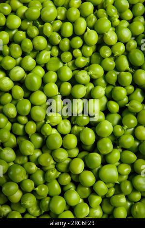 Background of fresh green peas, texture of perfect grains of peeled sweet peas as a background, top view, close-up. Vegetable background, vegetable pr Stock Photo