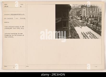 The 77th Division, part of the American military in World War One, is seen marching in formation on 5th Avenue in New York City. The photograph was taken on May 9th, 1919 by Sgt. McGarrigle. This image was captured during a parade and shows the infantry marching at the intersection of 5th Avenue and 41st Street. Stock Photo