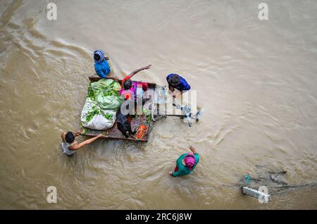 New Delhi, India. 12th July, 2023. NEW DELHI, INDIA - JULY 12: People from low-lying areas around the Yamuna river wade through floodwaters of the swollen river while relocating to a safer place, near Mayur Vihar riverside on July 12, 2023 in New Delhi, India. (Photo by Raj K Raj/Hindustan Times/Sipa USA) Credit: Sipa USA/Alamy Live News Stock Photo
