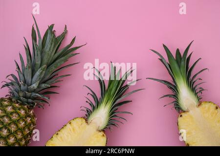 Whole and cut ripe pineapples on pink background, flat lay Stock Photo