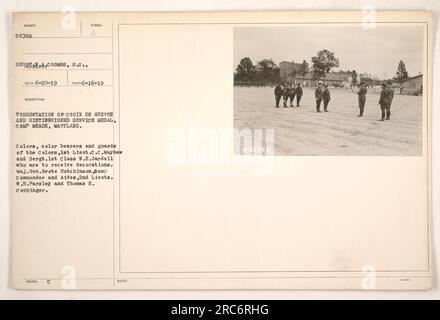 Presentation of Croix de Guerre and Distinguished Service Medal at Camp Meade, Maryland. The ceremony includes the colors, color bearers, and guards of the colors, 1st Lieut. C.C. Mayhew and Sergt. 1st Class N.E. Jardell. Maj. Gen. Grote Hutchinson, Camp Commander, along with Aides 2nd Lieuts. W.E. Parsley and Thomas E. Coppinger are present. Photograph taken on June 16, 1919. Official military record number: 56768. Stock Photo