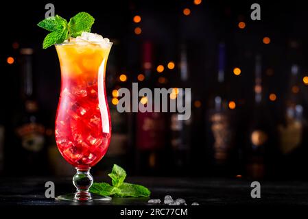 Aruba Ariba alcoholic cocktail drink with vodka, white rum, orange, lemon and pineapple juice, grenadine, dark bar counter background, copy space Stock Photo