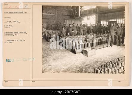 Caption: Workers at Bethlehem Steel Company in Bethlehem, PA, load 3.3' shells with TNT during World War I. This photograph, taken by photographer RECO on September 24, 1918, focuses on the crucial production of artillery ammunition. The image is marked as 'FOR OFFICIAL USE ONLY WUED NOTES.' Stock Photo
