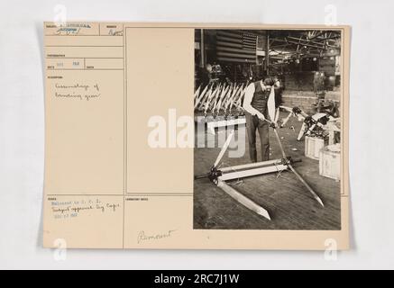 Workers assembling the landing gear of a USA airplane during World War One. Photograph taken in December 1917. The image shows a group of workers working together to mount the landing gear. Release approved by C.P.I Subject on December 27, 1917. Stock Photo