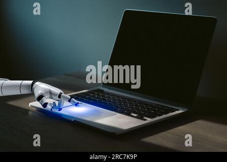 robot finger point to laptop button control and interface with technology AI artificial intelligence and automation. Stock Photo