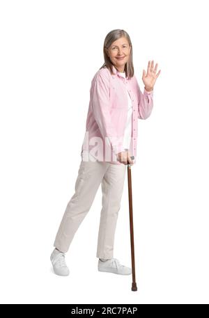 Senior woman with walking cane waving on white background Stock Photo ...