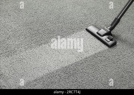 Vacuuming grey carpet. Clean area after using device. Space for text Stock Photo