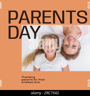 Parents day text on orange with portrait of happy caucasian mother and daughter lying on bed Stock Photo