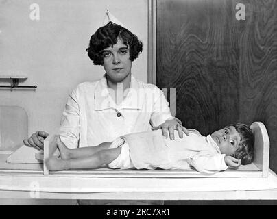 Washington, D.C., 1926. A nurse at the Children's Hospital measures the height of a wiggling child with this device. Stock Photo