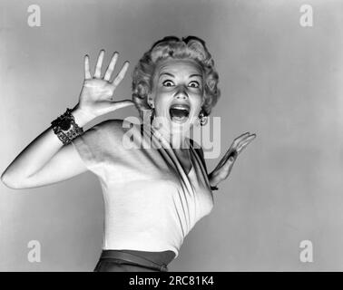 Hollywood, California:  1953.  Actress Kathleen Hughes reacts to the aliens in a promo still for the sc-fi thriller movie, 'It Came From Outer Space'. It was Universal Studio's first movie to be filmed in 3-D. Stock Photo