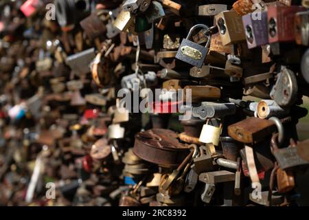 Thousands of love padlocks attached to a bridge in Riga, Latvia. Narrow depth of field. Copy space on the blurred space left Stock Photo